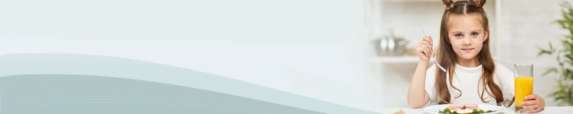 Young girl holding a glass of orange juice